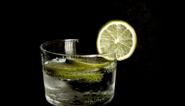 tonic with lime fruits isolated in black background